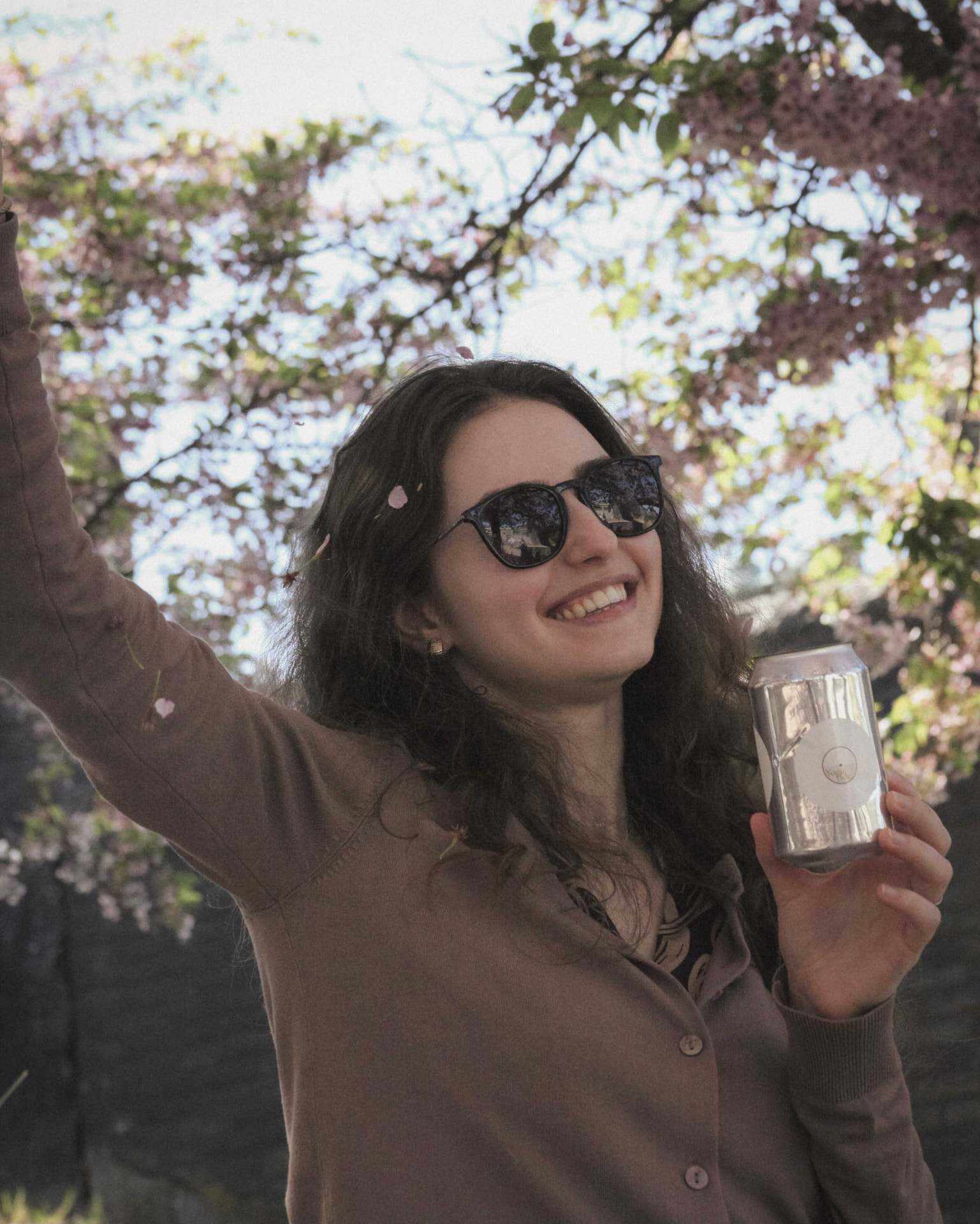Eva Smorodina holding a WonderFULL can among cherry blossom trees
